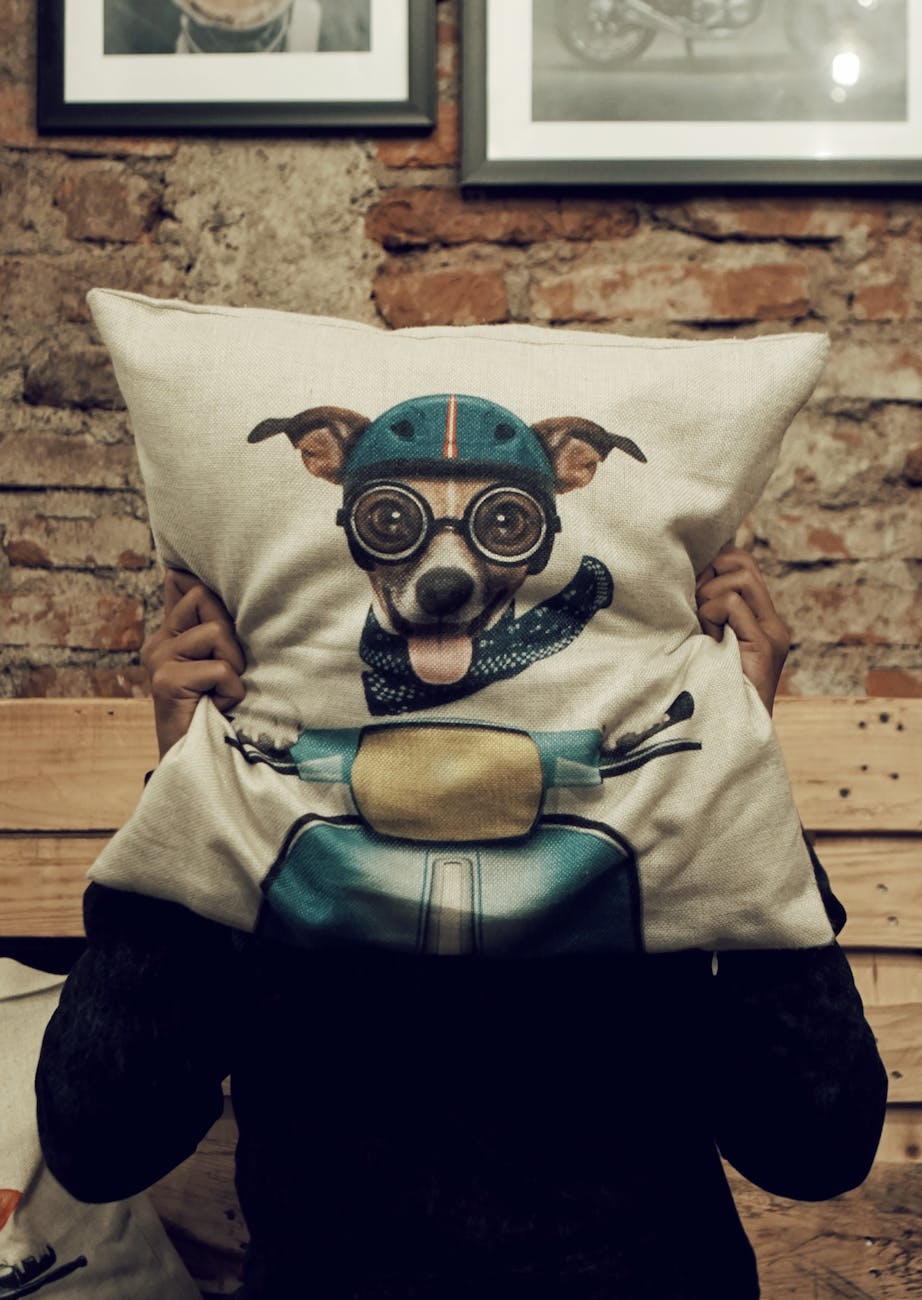 person holding dog driving scooter graphic throw pillow